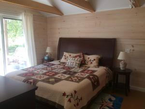 a bedroom with a bed with a quilt on it at Acadia Ocean Front Garden Cottages in Trenton