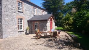 恩尼斯Knockaderry House的建筑物前有桌椅的露台