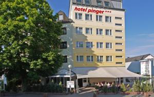 a hotel plunge building with people standing outside of it at Hotel Pinger in Remagen