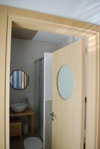 Casa Polly B&B في غْروتّامّاري: حمام مع حوض وباب مع مرآة