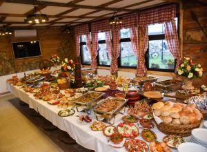 un lungo tavolo pieno di diversi tipi di cibo di Apostolovic Plus a Leskovac