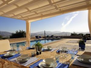 a dining table with glasses and a view of a pool at Casa Oasis in Alora
