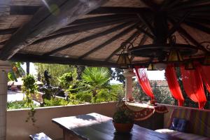a dining table under a roof with a table and a light at Villa Azur Cap d'Ail in Cap d'Ail
