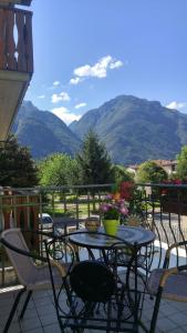 a table and chairs on a balcony with mountains at Casa "La Valle dei Segni" in Piancogno