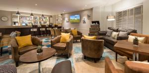 una sala de estar con sofás y sillas y un bar en Mode Hotel St Annes, en Lytham St Annes