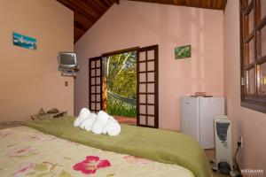 Un dormitorio con una cama con toallas y una ventana. en Pousada da Oma, en Cunha