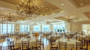 a banquet hall with tables and chairs and chandeliers at Beauport Hotel Gloucester in Gloucester