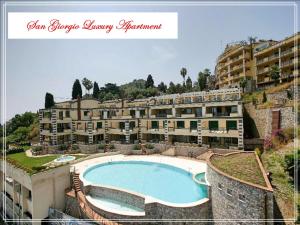 タオルミーナにあるSan Giorgio Luxury Apartment Taormina-Panoramic Pool & Parking Spaceのスイミングプール付きのリゾートの景色を望めます。