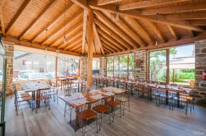 un restaurante con mesas y sillas en una habitación con ventanas en Hotel Rural La Bolera en Robles de Laciana