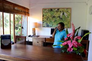 een vrouw die met een mobieltje praat in een kamer bij Chantauvent Guest House in Blue Bay