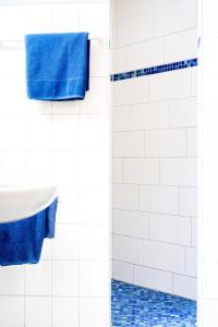 ein Badezimmer mit blauen Handtüchern und einer Dusche in der Unterkunft Gasthof - Hotel Kopf in Riegel