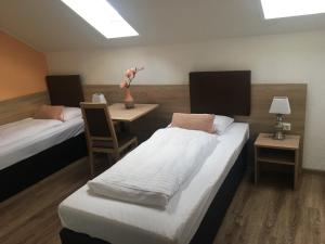 una habitación con 2 camas y una mesa con un jarrón de flores en Central Hotel Duisburg, en Duisburg