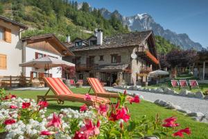 a bench in front of a lush green hillside at Hotel La Grange - Animal Chic Hotel in Courmayeur
