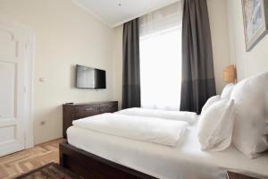 ブダペストにあるLuxury Apartment by Hi5 - Király street Suiteのベッド2台とテレビが備わるホテルルームです。