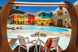 a pool at a resort with chairs and a table at Alexandra Golden Boutique Hotel-Adults Only in Chrysi Ammoudia
