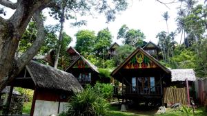 a group of houses with thatched roofs at Casa Nemo Beach Resort & Spa in Sabang