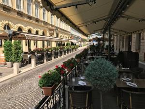 ein Restaurant mit Tischen und Blumen an einer Straße in der Unterkunft Vista Suites 1-2 in Budapest