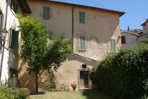 un gran edificio de piedra con ventanas con contraventanas verdes en Villa del Cardinale en Spoleto