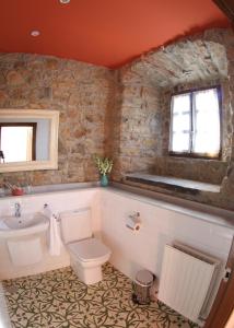 a bathroom with a toilet and a sink at Hotel Casona Cuervo in San Tirso de Candamo