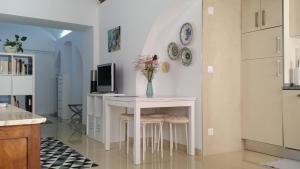 a kitchen with a table with a vase of flowers on it at Ebora Home - free garage - Centro Histórico in Évora