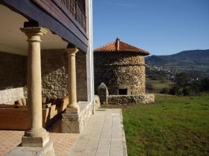 un edificio de piedra con una torre en una colina en Hotel Casona Cuervo, en San Tirso de Candamo