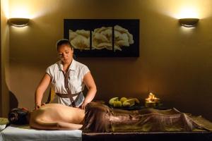 a woman getting a massage from a woman laying on a bed at Alexandra Golden Boutique Hotel-Adults Only in Chrysi Ammoudia