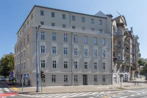 ポズナンにあるPoznan Rents - Apartamenty Mostowa Old Town Parking Freeの通角の白い大きな建物