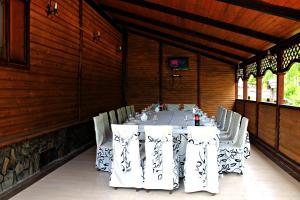 une salle à manger avec une table et des chaises blanches dans l'établissement Orlyne Gnizdo, à Tchernivtsi