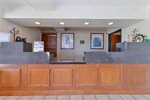 a lobby with a counter with wood and gray granite at Executive Plus Inn and Suites in Elk City