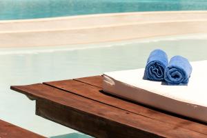 a table with blue towels on it next to a swimming pool at Alexandra Golden Boutique Hotel-Adults Only in Chrysi Ammoudia