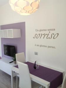 a dining room with a table and a sign on the wall at Appartamento Elisa 50m Trenino Rosso in Tirano