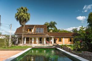 モヘチスにあるCasa da Estacao - Não é hotel, não é pousada é a casa mais charmosa de Morretes!の家の前にプールがある家