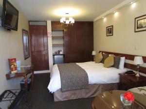 A bed or beds in a room at Queen's Villa Hotel Boutique