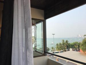 a room with a window with a view of the ocean at Lewiinski's Hotel in Pattaya Central