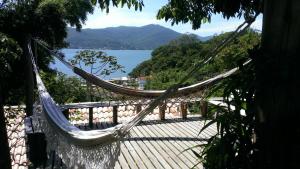 uma rede de descanso num deque com vista para um lago em Studio Formana em Florianópolis