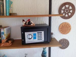 a shelf with a small microwave with two figurines on it at Studio Formana in Florianópolis
