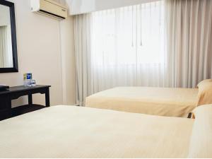 a hotel room with two beds and a window at Hotel Miraflores Villahermosa in Villahermosa