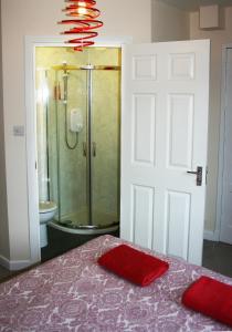 a bathroom with a shower and a bed with a red towel at Park View in Ballachulish