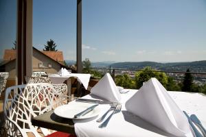 a table with white plates and utensils on a balcony at Restaurant-Hotel Maien in Lörrach