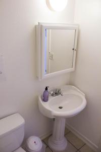 uma casa de banho com um lavatório, um espelho e um WC. em Libra Hotel em Los Angeles