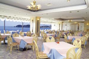 a banquet room with tables and chairs with a view of the ocean at Shibushiwan Daikoku Resort Hotel in Shibushi
