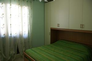 - une chambre avec un lit et une fenêtre avec des rideaux dans l'établissement Appartamento Torre, à Finale