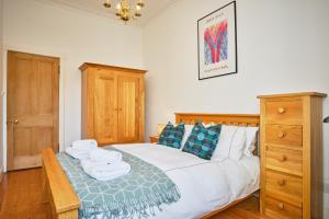 um quarto com uma cama com toalhas em Comely Bank Apartment em Edinburgo