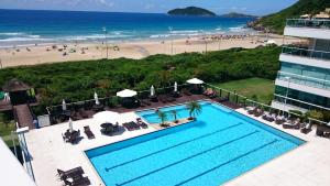 una vista aérea de una piscina junto a la playa en Águas do Santinho Apart, en Florianópolis