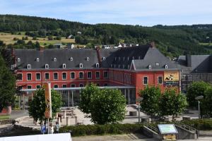 a large red building in front of a mountain at L'Auberge Saint Remacle in Stavelot