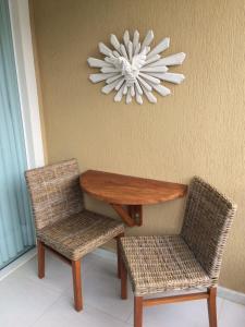 a table and two chairs and a chandelier at Charming Guarajuba in Guarajuba