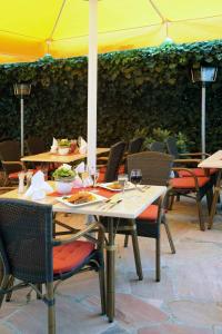 a table with glasses of wine on a patio at Hotel & Restaurant Hugenottengarten in Friedrichsdorf