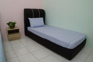 - un lit dans une chambre avec un oreiller et une table dans l'établissement Taiping Cozy Homestay, à Taiping