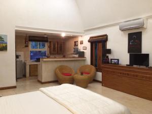 a large room with a kitchen with a bed and chairs at Studio Lumbung in Lovina