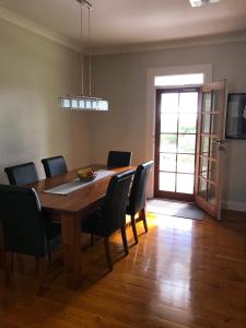 uma sala de jantar com uma mesa de madeira e cadeiras em Girraween House em Coonawarra